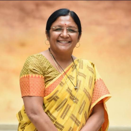 Portrait of Smt. Savitri Thakur in a yellow handwoven sari.