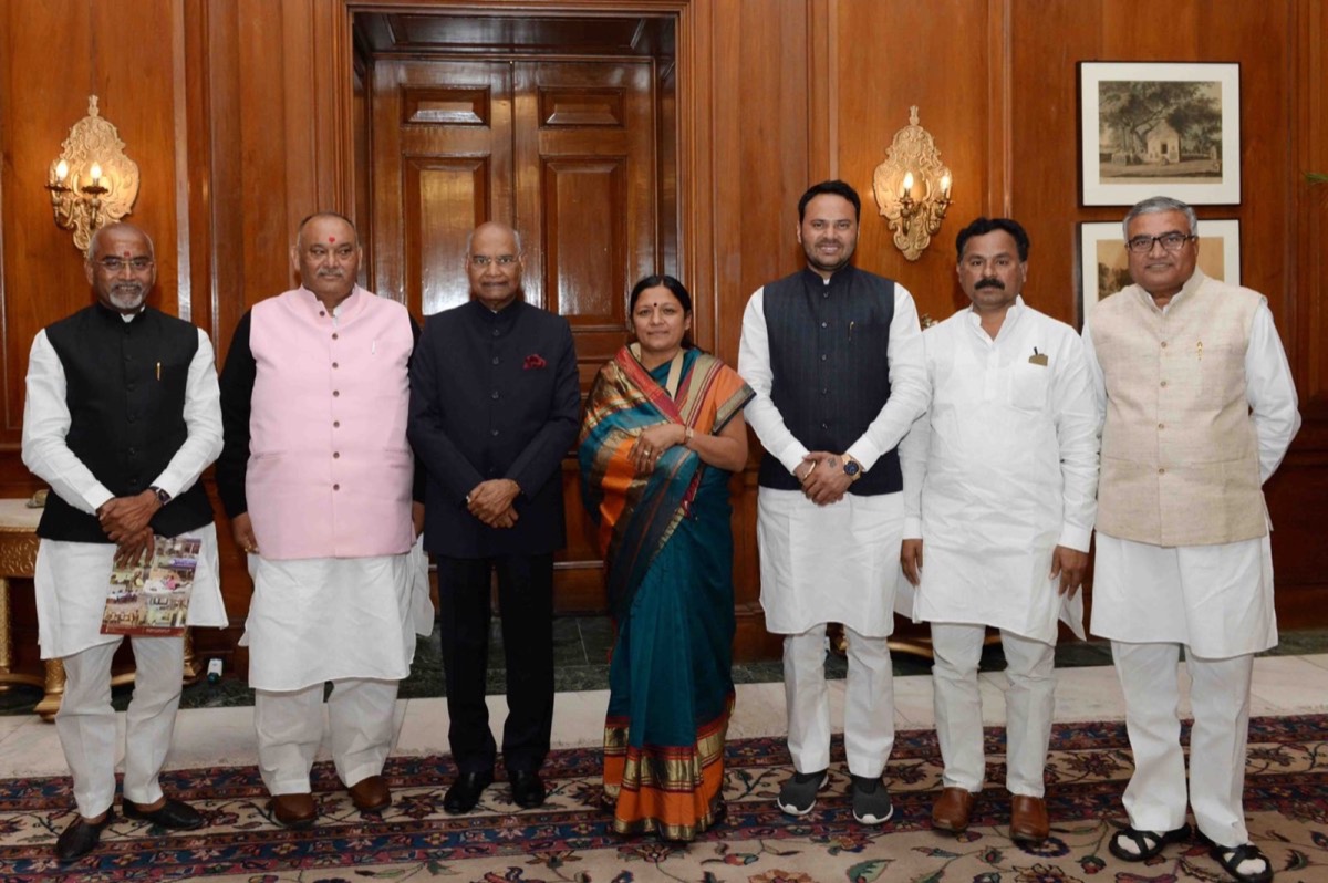 A group of parliamentarians standing with the then President of India in a wood-panelled reception room at Rashtrapati Bhavan.