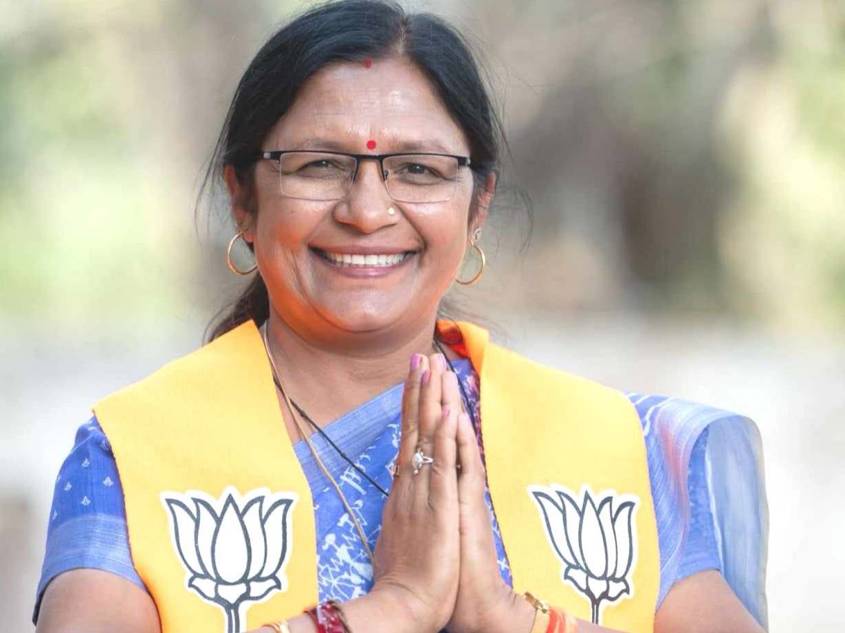 Smt. Savitri Thakur with hands folded in greeting, photographed outdoors.