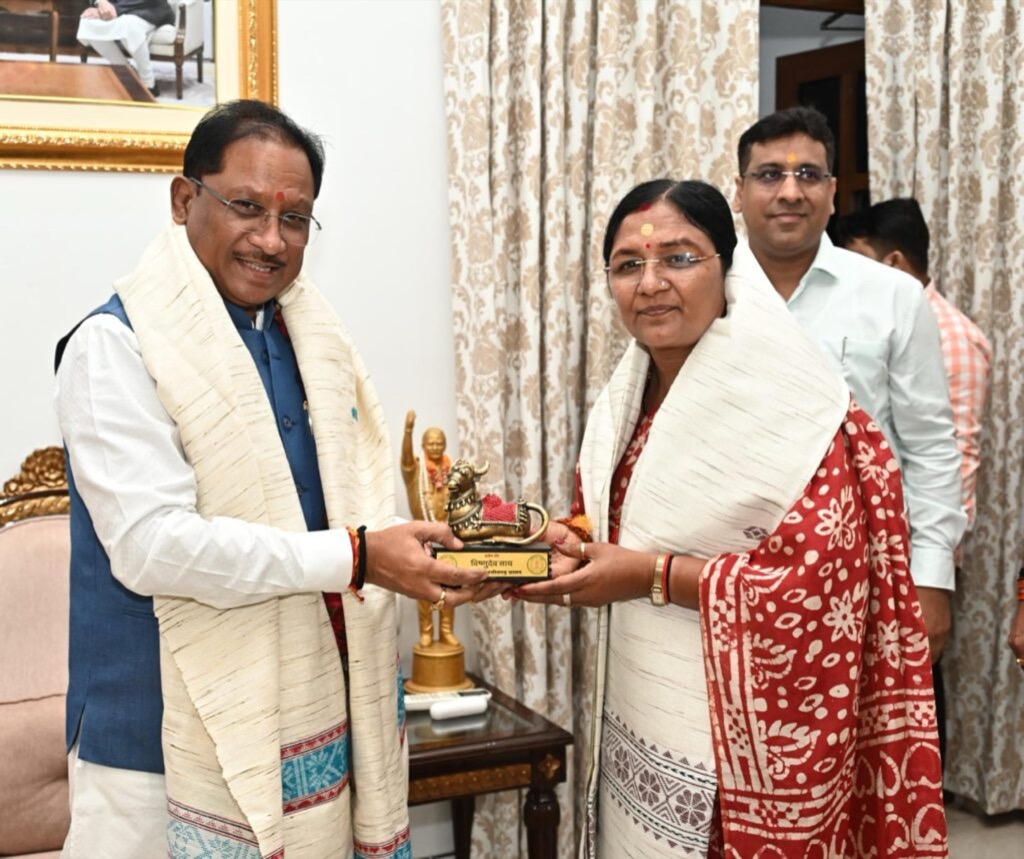 Smt. Savitri Thakur receiving a memento from a State Chief Minister, both wearing ceremonial shawls.