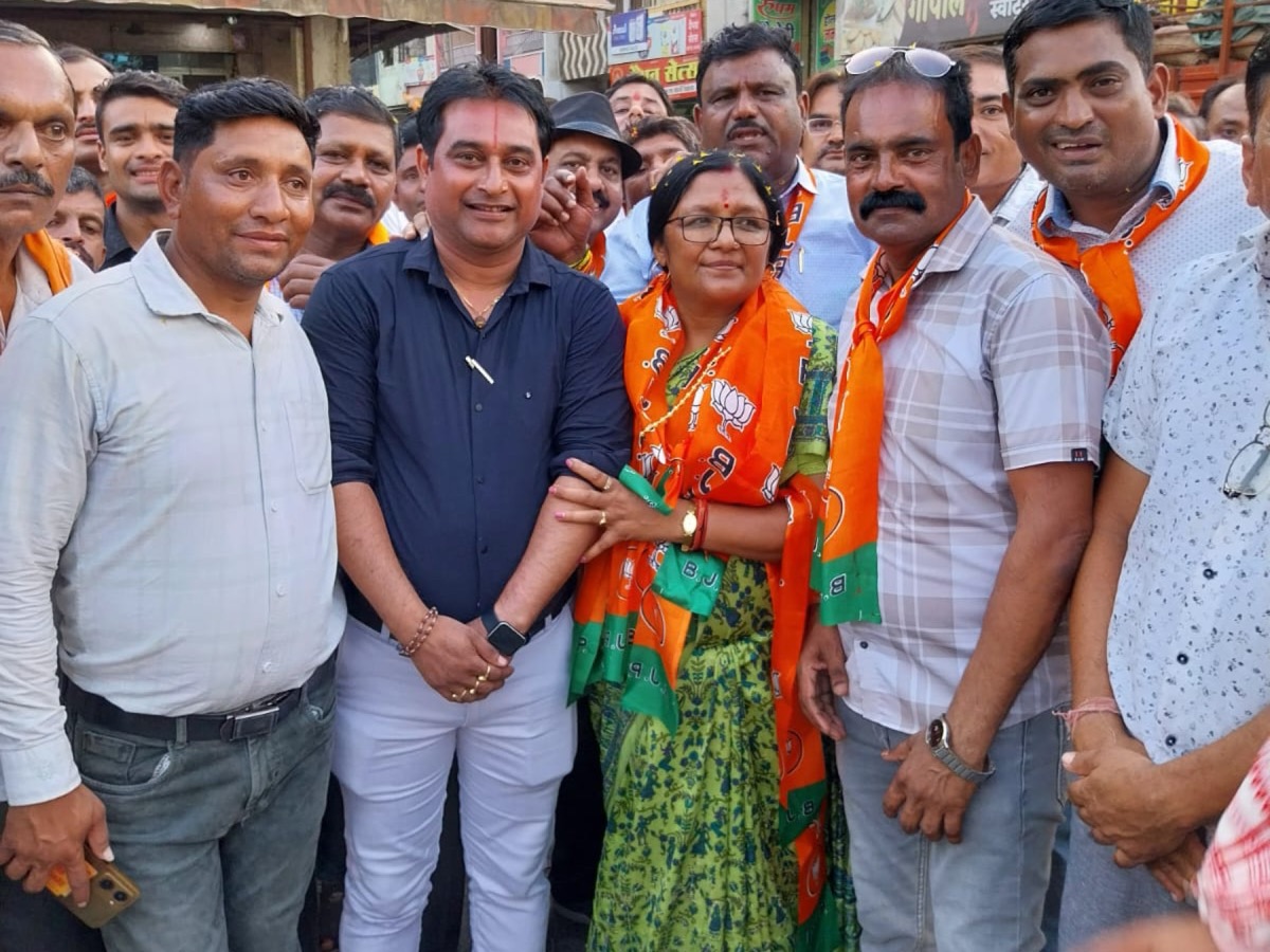 Smt. Savitri Thakur standing among a group of people on a street in Dhar, Madhya Pradesh.