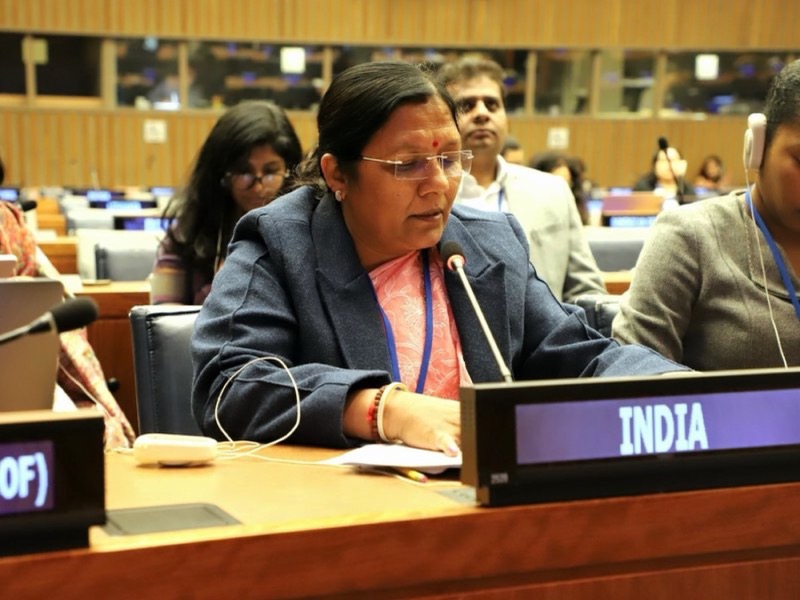 Smt. Savitri Thakur speaking into a microphone at a United Nations conference desk marked INDIA, with other delegates seated nearby.